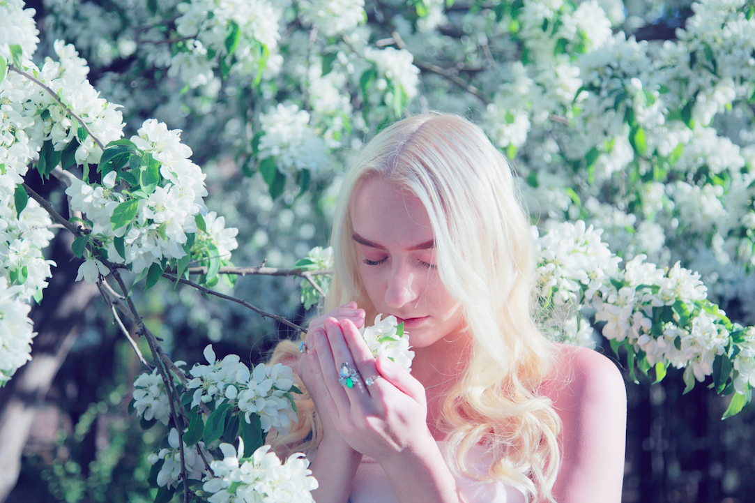 Girl smelling flowers. Photo by Sharon McCutcheon on Unsplash