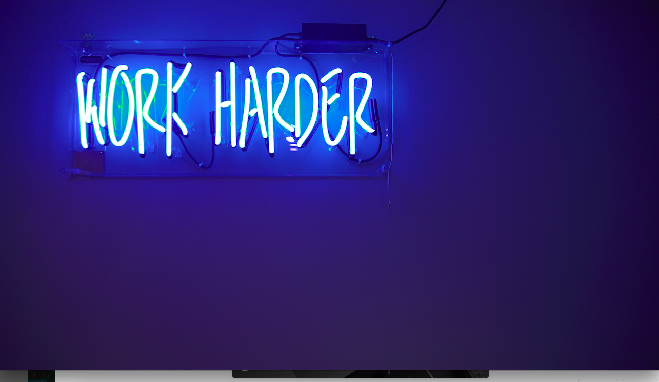 Work Harder blue neon light on the wall. Photo by Jordan Whitfield on Unsplash