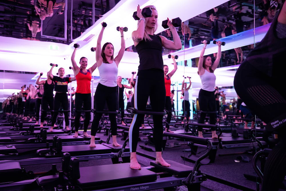 A fitness class in a dark room with lights flashing