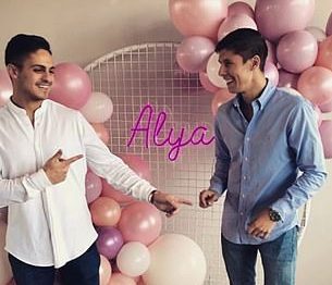 two men smiling at each other with pink and white balloons