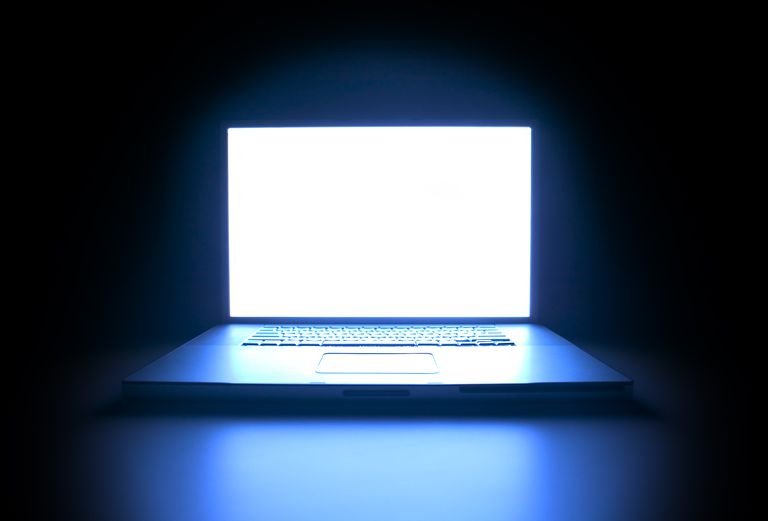 Blue light emitting from computer screen in a dark room.