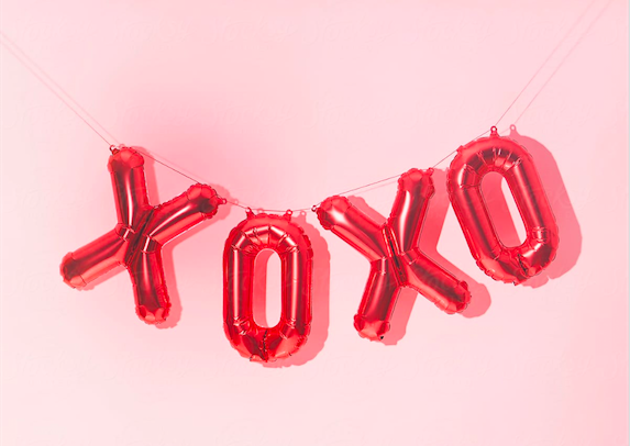 XOXO red balloons against baby pink backdrop