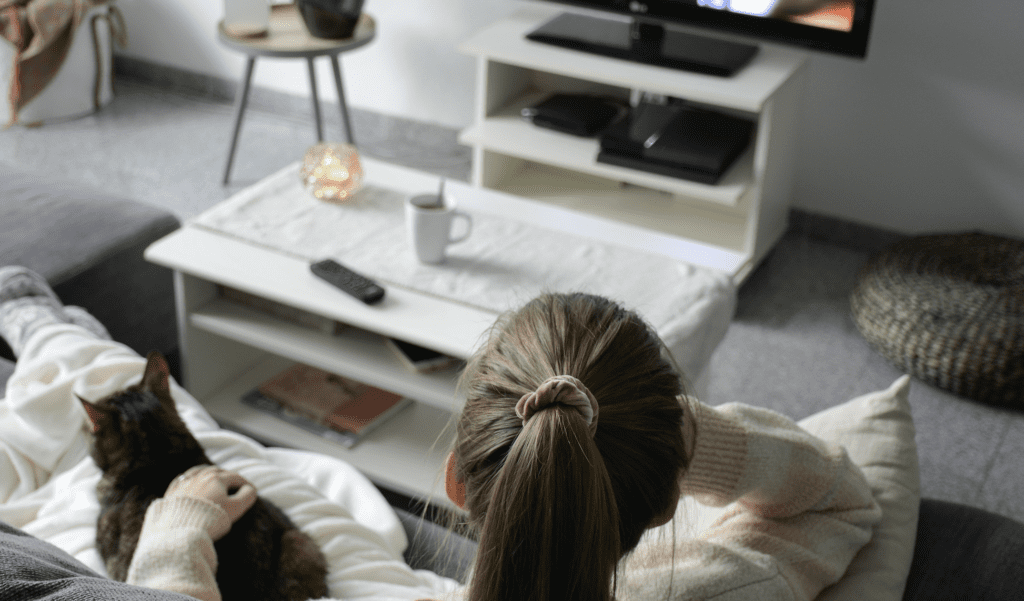 a woman at home watching too much news on the pandemic