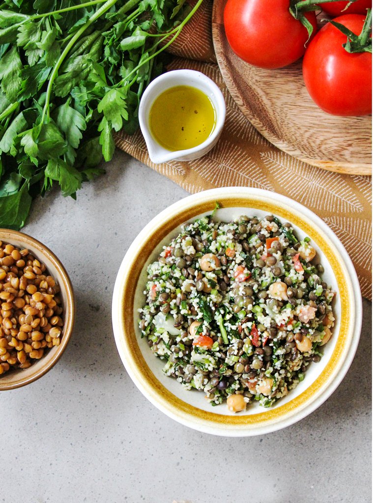 Lentil Salad in bowl with sauce, tomato and vegetables.