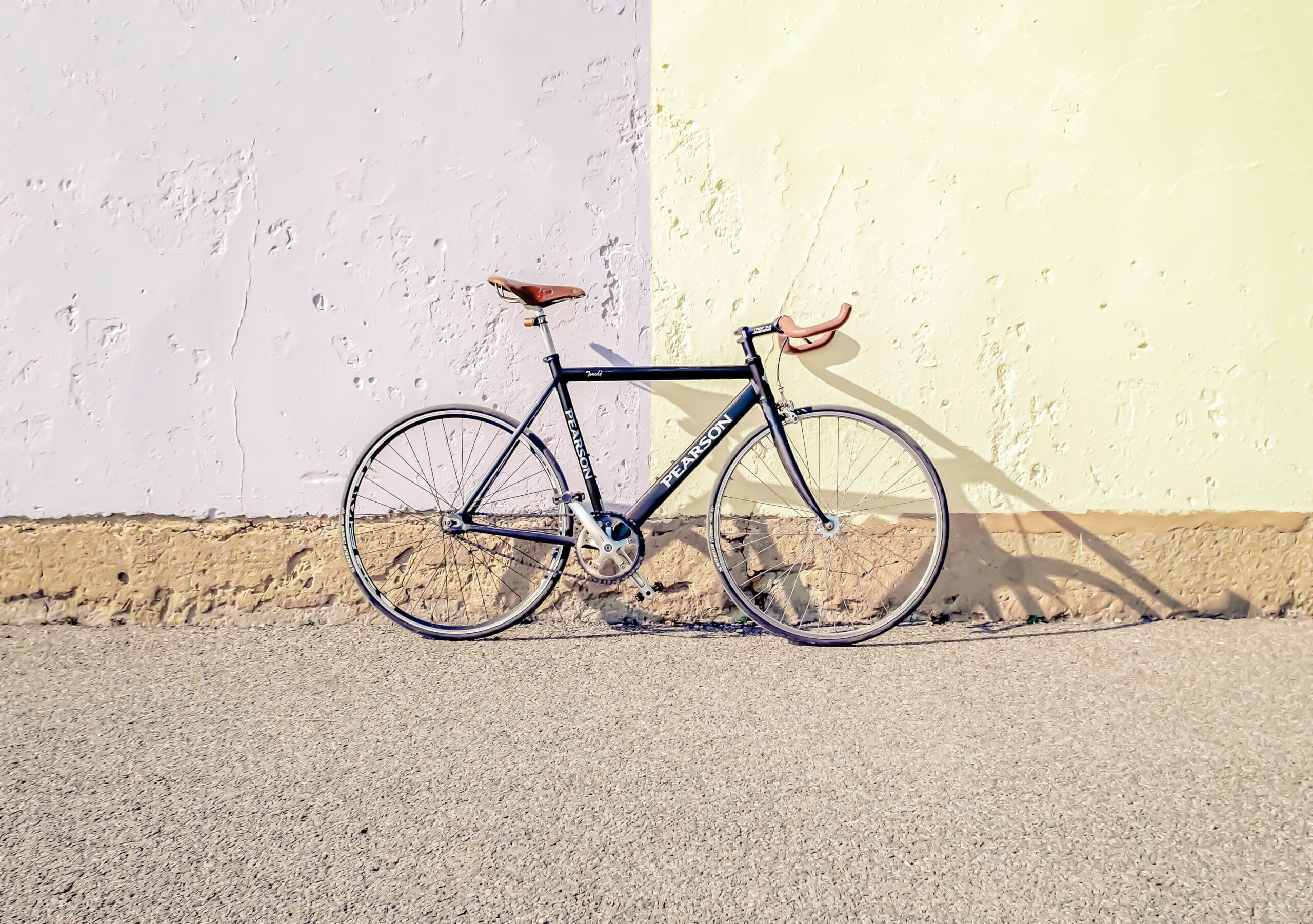 Bicycle leaning on pale coloured wall