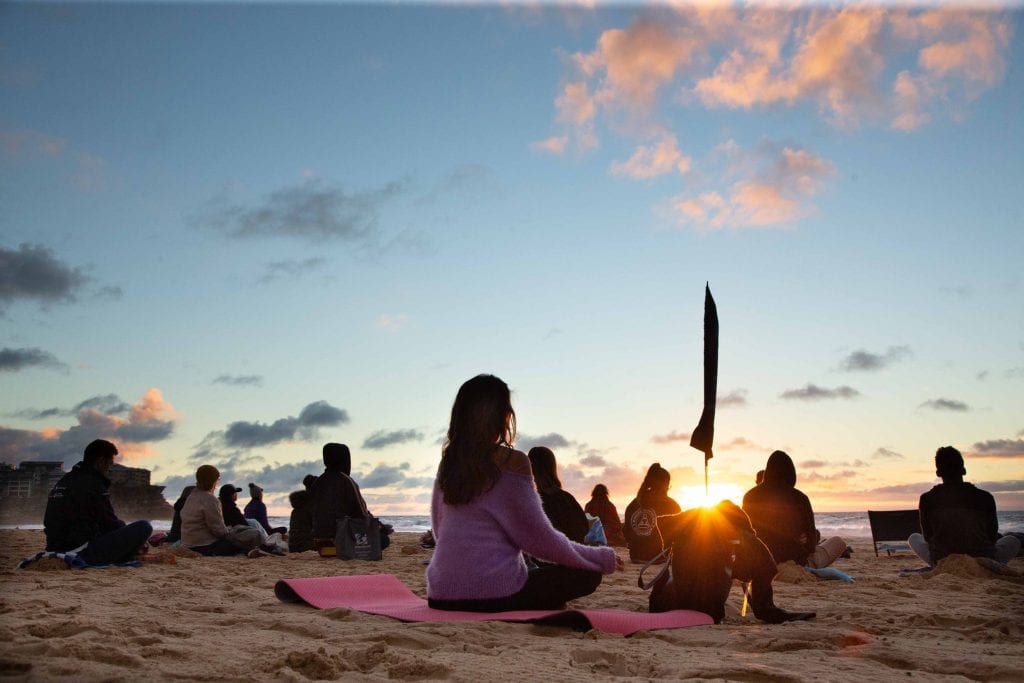 people meditating on the beach. Bondi Beach. Making meditation mainstream.