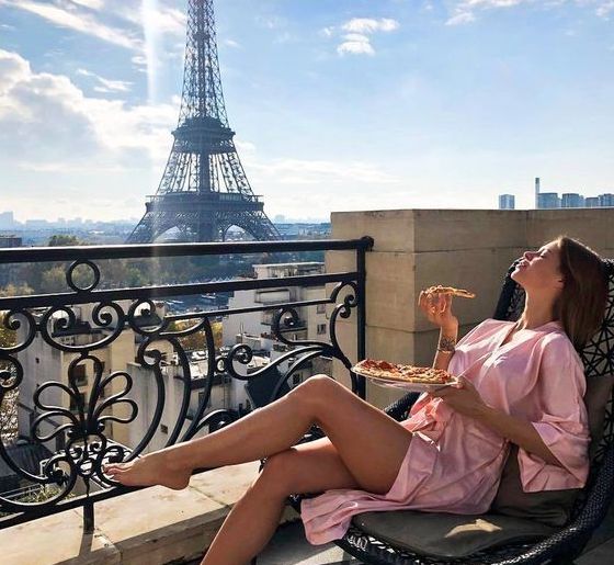 Woman lounging in front of the Eiffel Tower.