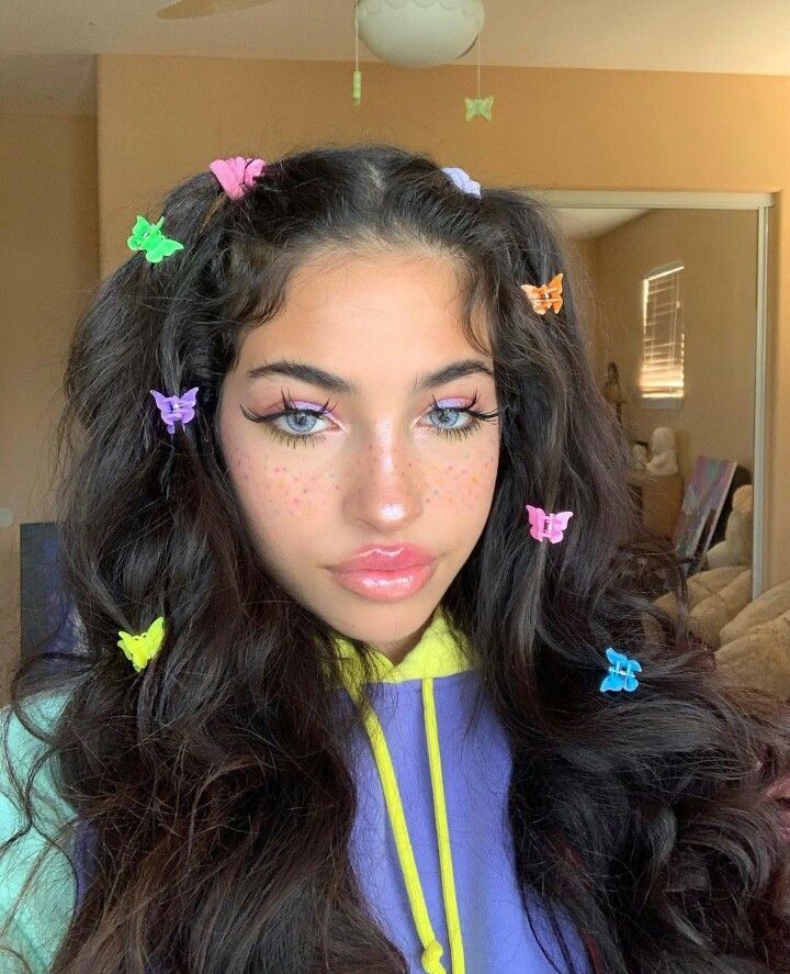 Female wearing colourful butterfly clips in her hair.