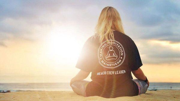 A Making Meditation Mainstream participant. A blonde woman meditating on the beach. Bondi Beach.