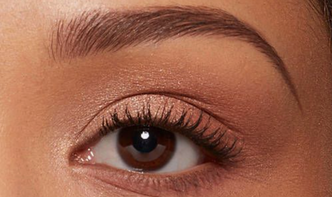 Close up of woman's eye and thinner brow with natural makeup
