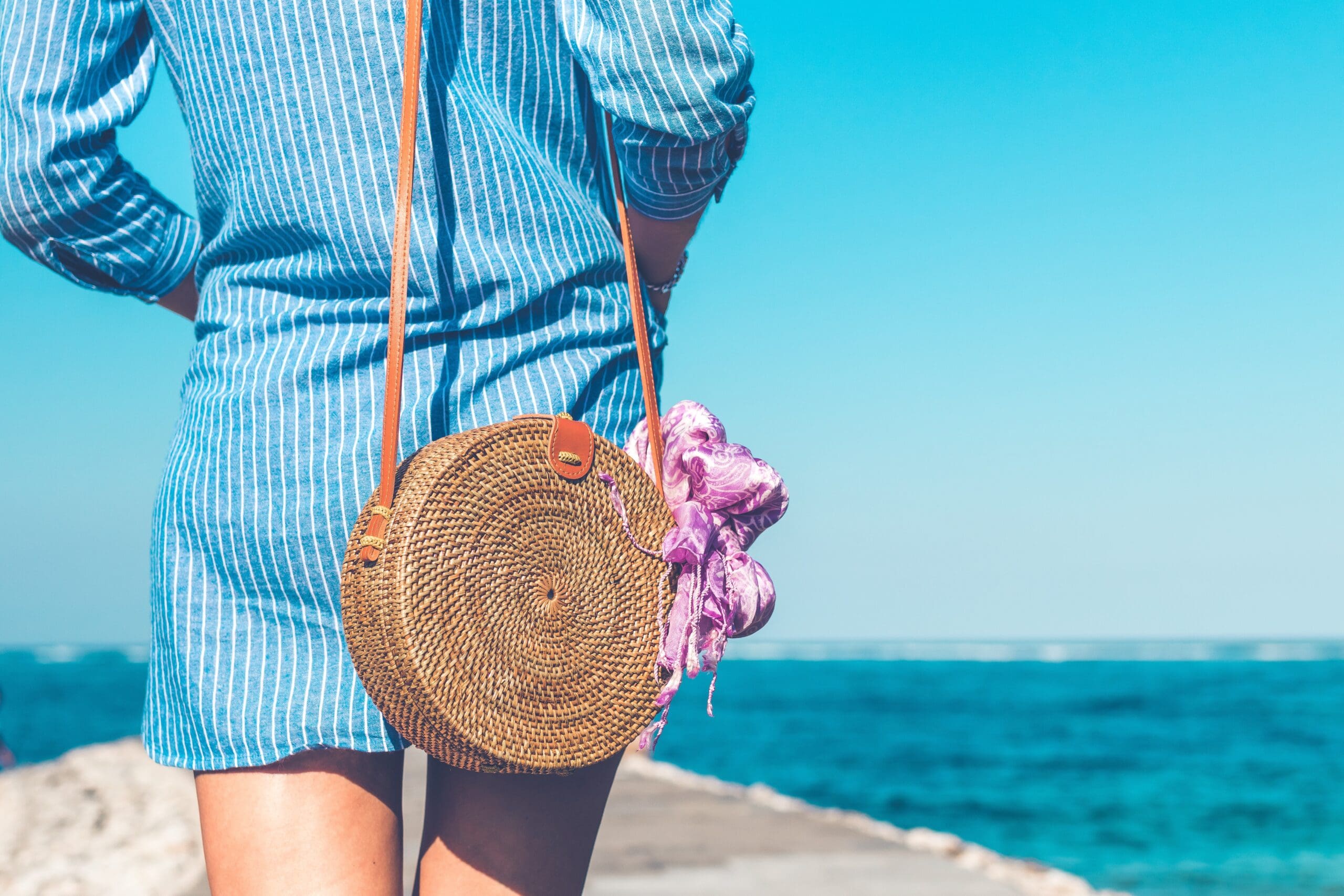 Girl on beach with handbag