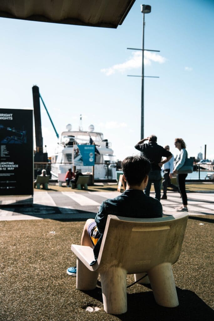 A man sits alone watching people around him. Source: Unsplash.