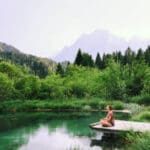 person meditating at a lake