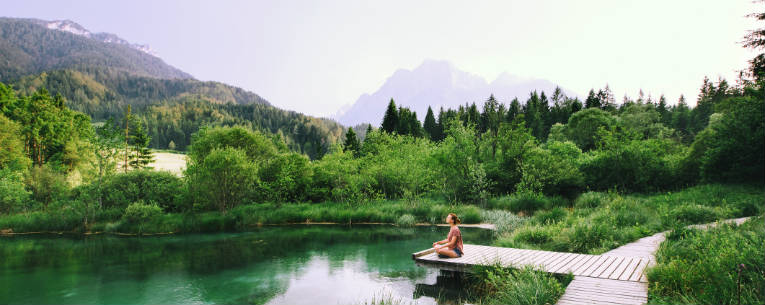 person meditating at a lake