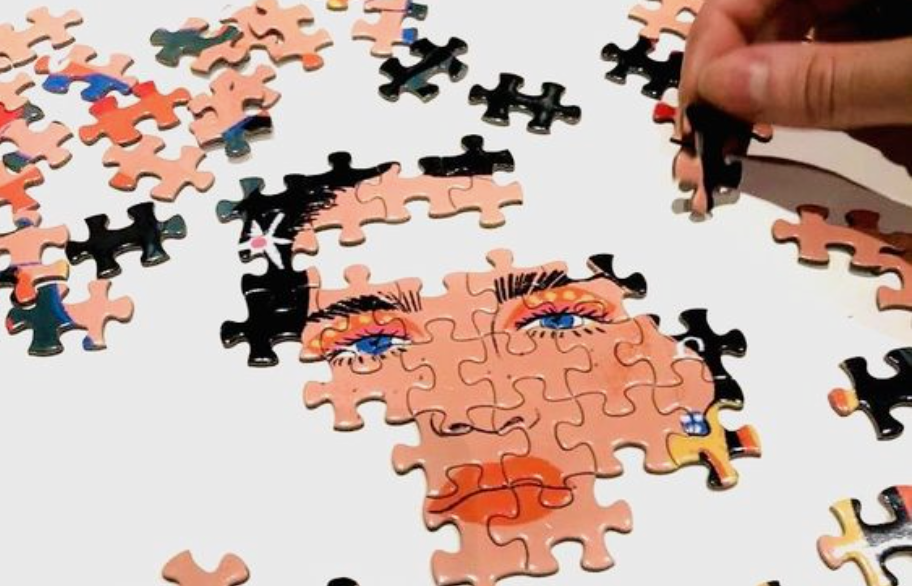 Jigsaw puzzle being built with woman in middle