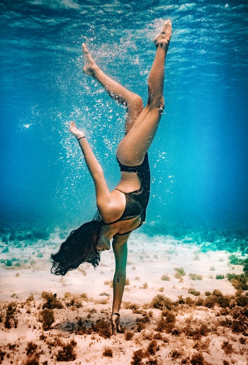brunette woman in black swimsuit under water