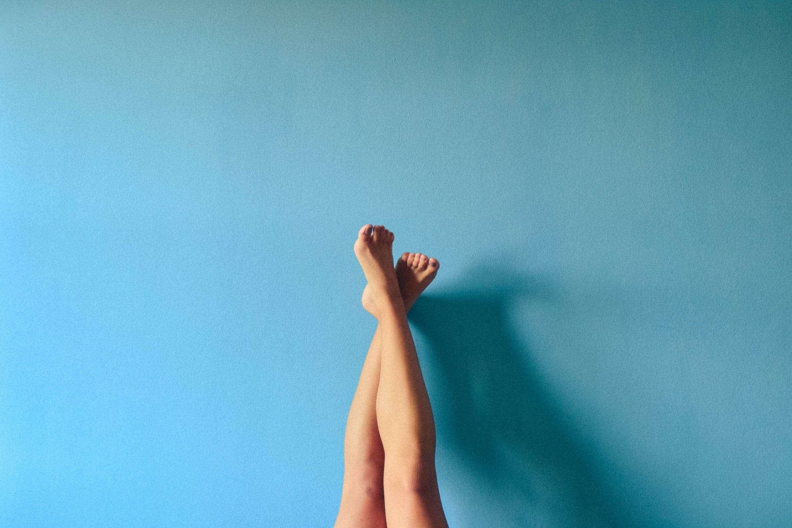 woman's legs against a blue wall