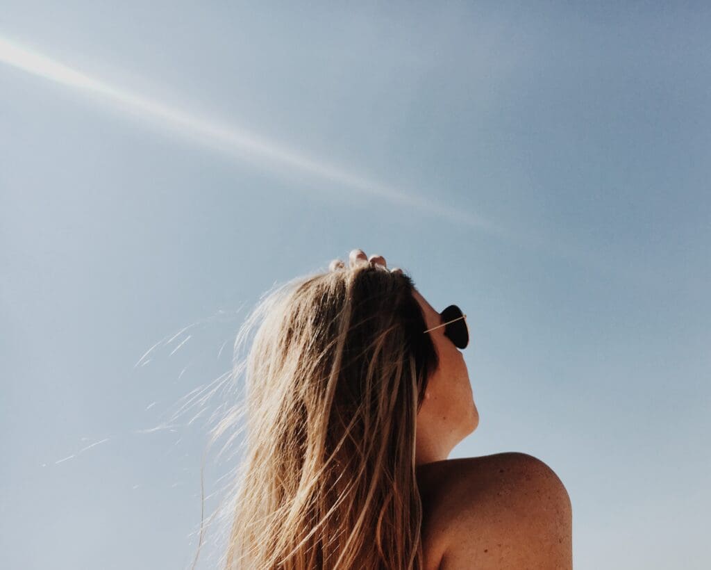 blonde young woman looking at the sky