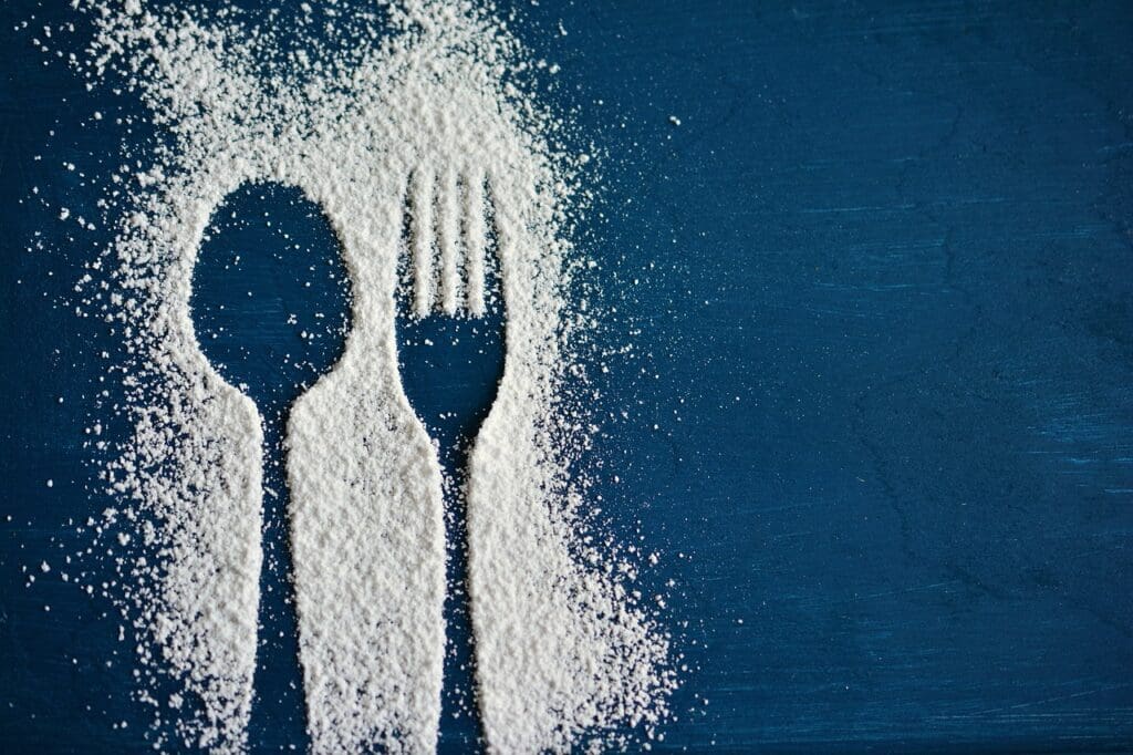 sugar on blue table cloth with knife and fork imprint