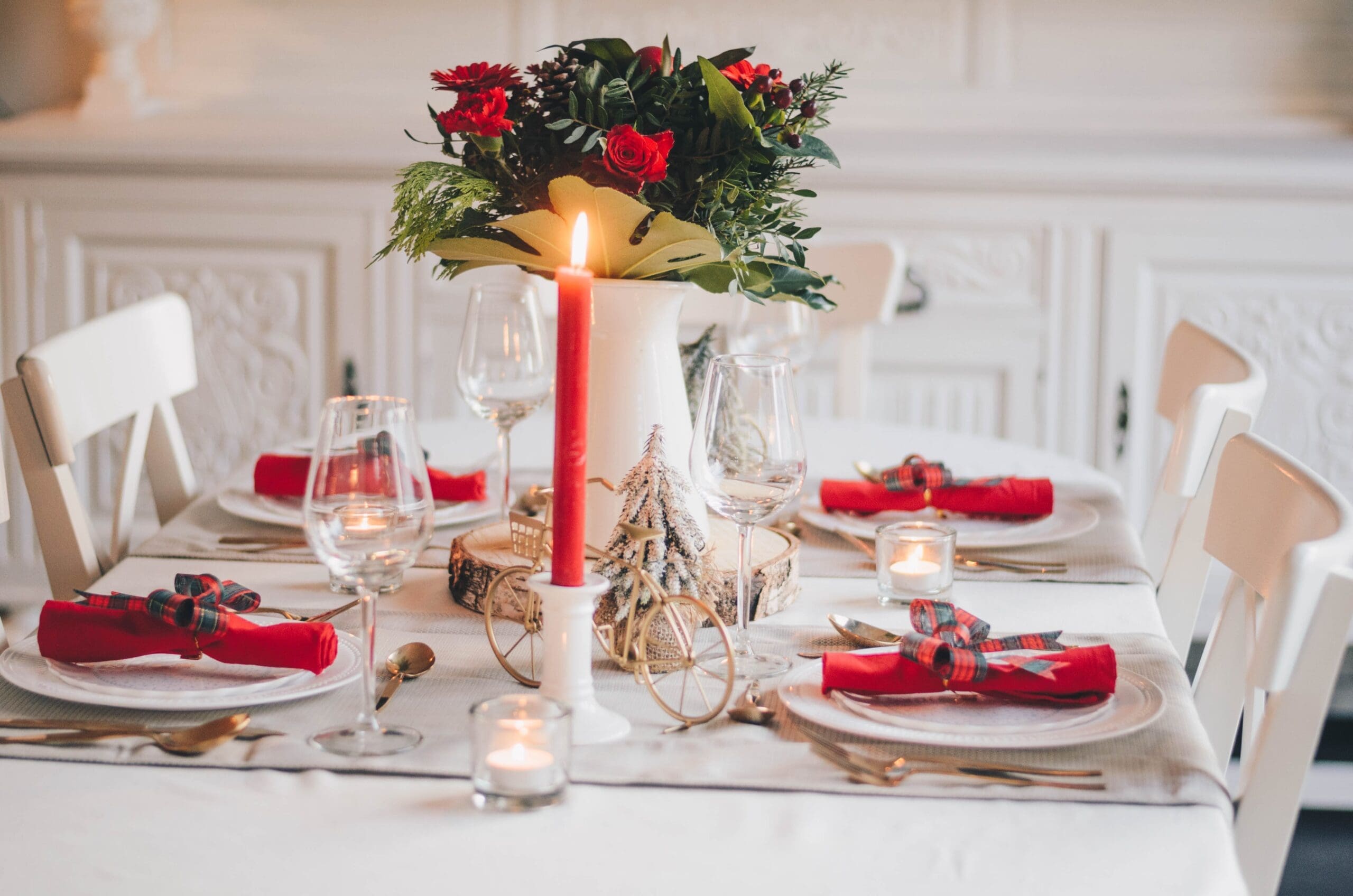 Red and white Christmas themed dinner set-up with flowers