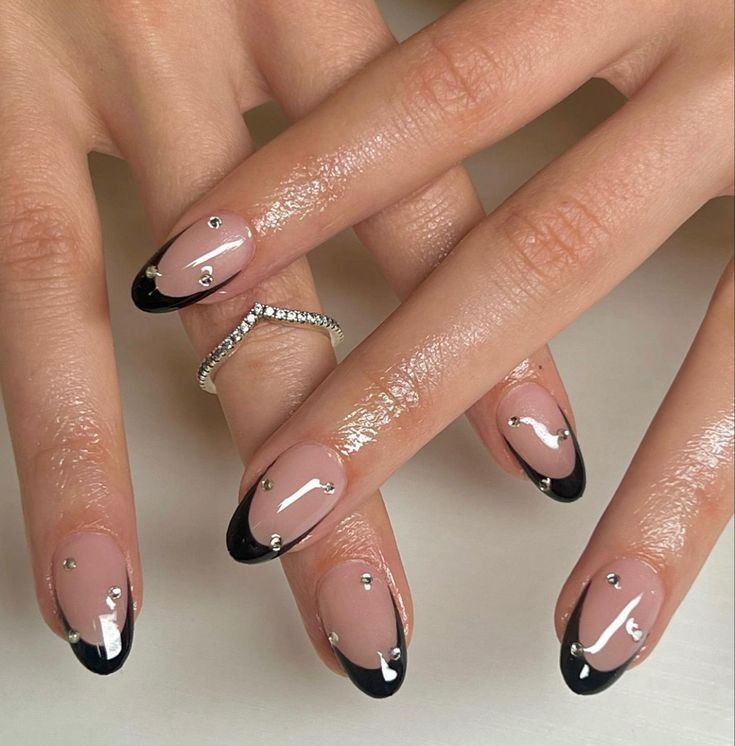 Nails with black french tip and rhinestones all around the nail.